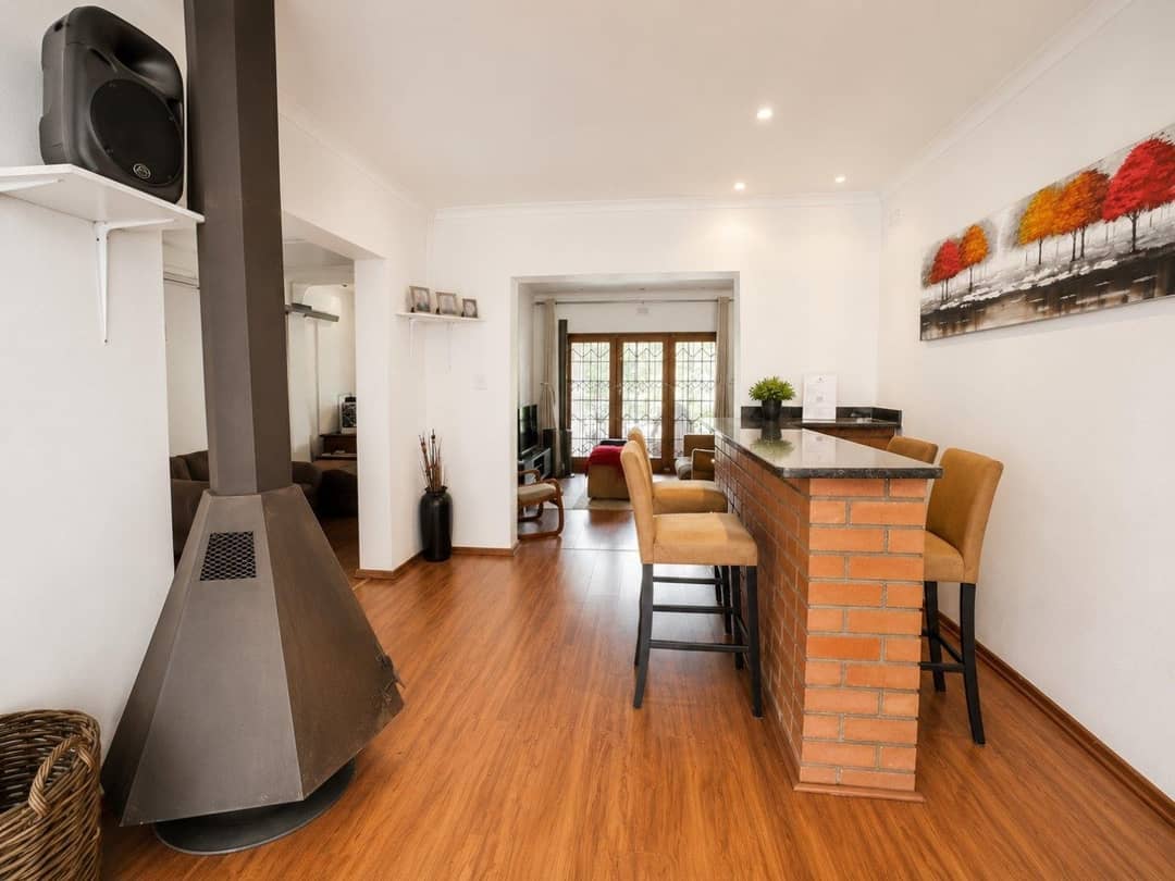 Indoor bar with a brick-faced counter, bar stools and a freestanding cone fireplace